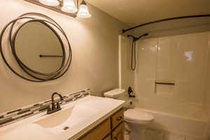 Downstairs updated full Bathroom featuring vanity, and tile backsplash. new floors