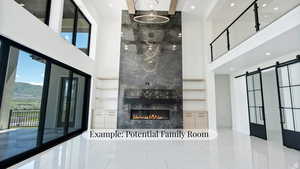Unfurnished living room featuring a barn door, a high ceiling, a mountain view, recessed lighting, and a premium fireplace