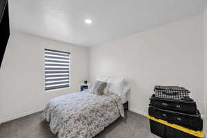 Bedroom featuring carpet floors and baseboards