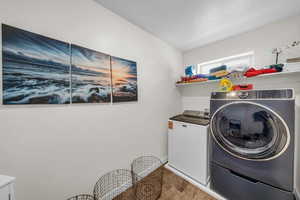 Laundry room with parquet floors and washer and dryer