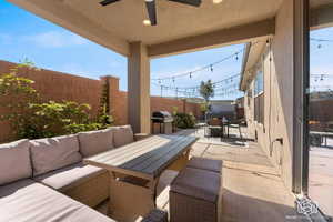Fenced backyard with a patio area, outdoor lounge area, a ceiling fan, and a grill