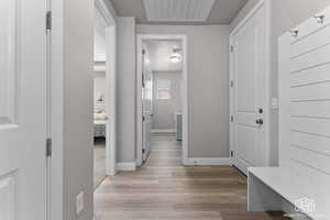 Hallway with baseboards and light wood-style flooring