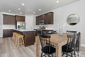 Dining room with light wood-style flooring, ceiling fan, and recessed lighting