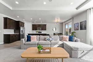 Living room with a chandelier, light colored carpet, and a textured ceiling