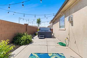 Fenced backyard featuring a patio and a hot tub