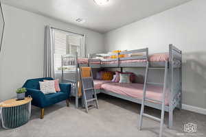 Bedroom featuring light carpet