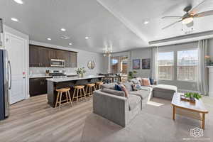 Living area with a ceiling fan, healthy amount of natural light, a textured ceiling, recessed lighting, and light wood-type flooring