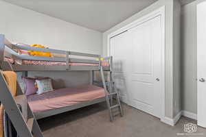 Bedroom featuring light carpet and a closet