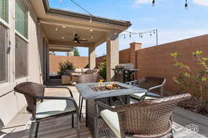 Fenced backyard featuring an outdoor living space with a fire pit, ceiling fan, a patio, and grilling area