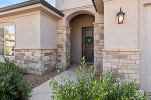 Property entrance with stone siding and stucco siding