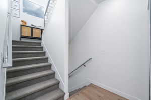 Stairs with wood finished floors and baseboards
