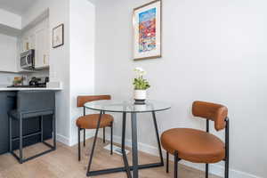 Dining space with light wood-style flooring and baseboards