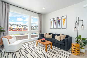 Living area with light wood-type flooring, recessed lighting, and a residential view