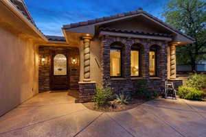 View of front facade featuring stone siding, a tiled roof, and stucco siding