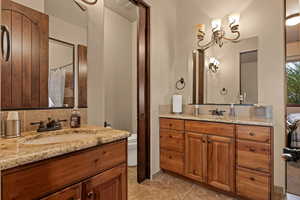 Bathroom with a shower with shower curtain, two vanities, and light tile patterned floors