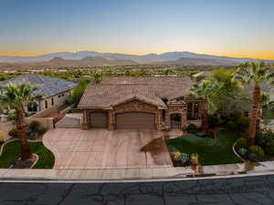 Mediterranean / spanish home with a gate, an attached garage, driveway, a mountain view, and stone siding