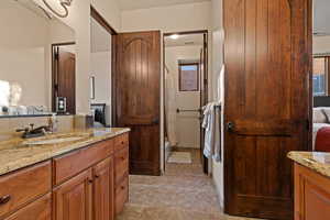 Full bathroom with vanity, shower / tub combo with curtain, and ensuite bathroom