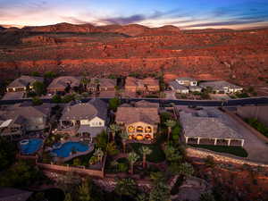 Aerial view at dusk of a residential view, a mountain view, and view of pool