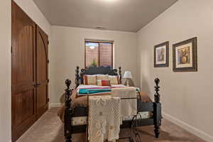 Carpeted bedroom with baseboards and a closet