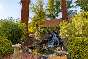 Fenced yard featuring a small pond