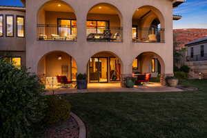Back of house featuring stucco siding, a patio area, and a balcony
