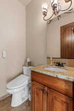 Half bath featuring vanity and dark tile patterned flooring