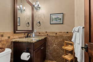 Bathroom featuring tile walls, vanity, and wainscoting