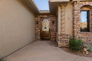 View of exterior entry featuring stone siding and stucco siding