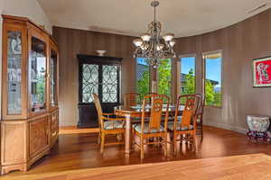 Dining room with suspended lighting and hardwood / wood-style flooring