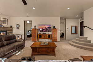 Living area with carpet flooring, a fireplace, a ceiling fan, and recessed lighting