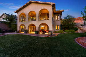 Back of house with stucco siding, a patio area, a balcony, and ceiling fan