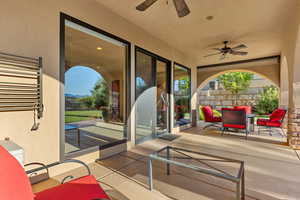 View of patio with a ceiling fan and radiator heating unit