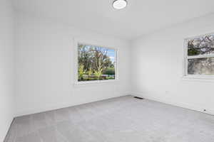 Empty room featuring light carpet and baseboards