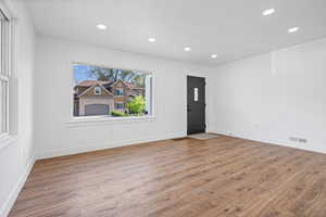 Entrance foyer with light wood-type flooring and recessed lighting