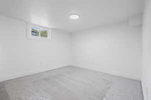 Spare room featuring light carpet and baseboards