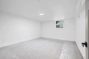 Empty room featuring light carpet and baseboards