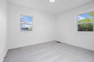 Spare room with light carpet and baseboards