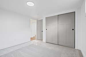 Unfurnished bedroom with baseboards and a closet