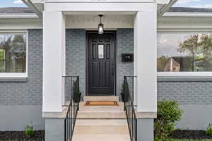Doorway to property featuring brick siding