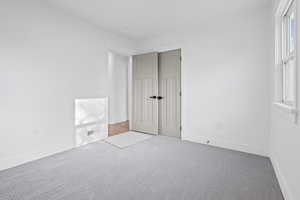 Unfurnished bedroom featuring carpet and baseboards