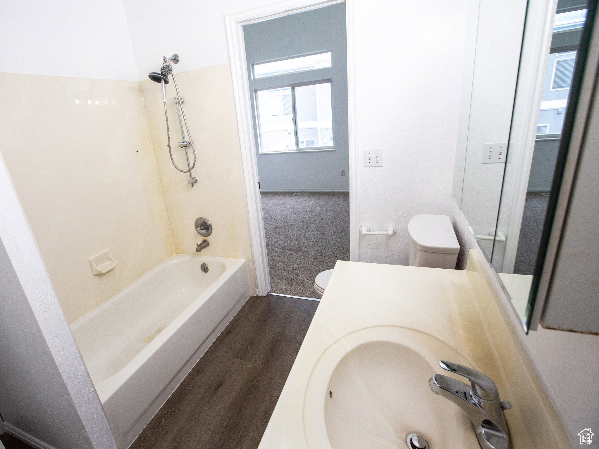 Full bath featuring dark wood finished floors, shower / tub combination, and vanity