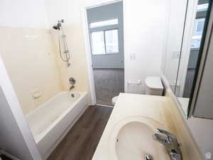 Full bath featuring dark wood finished floors, shower / tub combination, and vanity