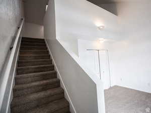 Staircase with carpet flooring and baseboards