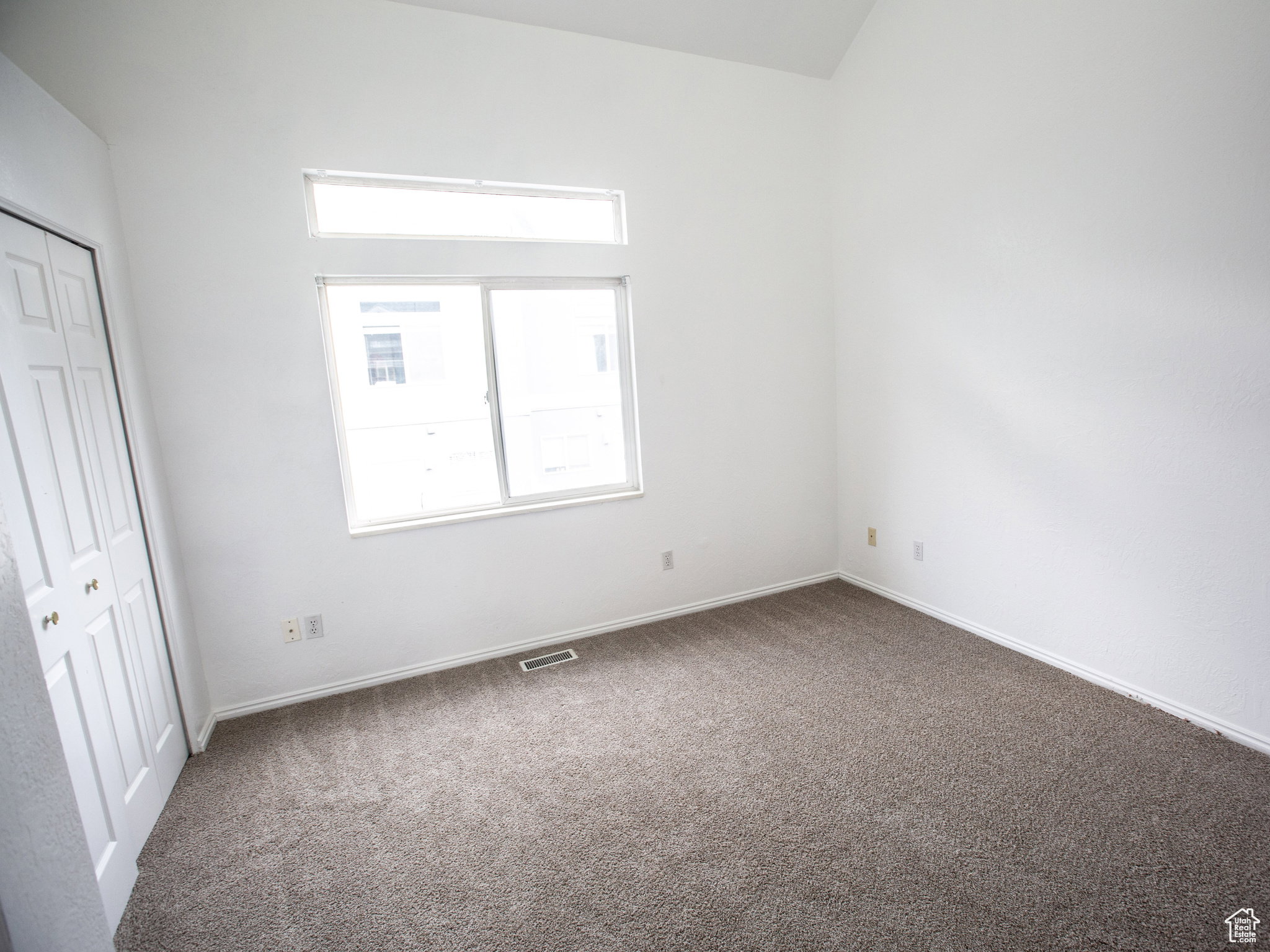 Unfurnished bedroom featuring dark colored carpet and a closet