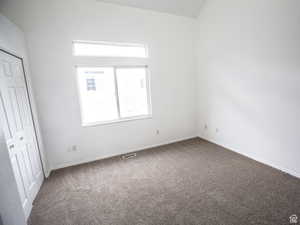 Unfurnished bedroom featuring dark colored carpet and a closet