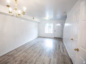 Entryway with wood finished floors and hanging lights