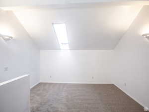 Additional living space with carpet floors and vaulted ceiling