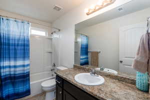 Full bath featuring vanity and shower / bath combination with curtain