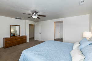 Bedroom with dark carpet and ceiling fan