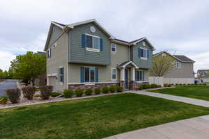 View of front of home featuring stone siding, stucco siding, and a garage